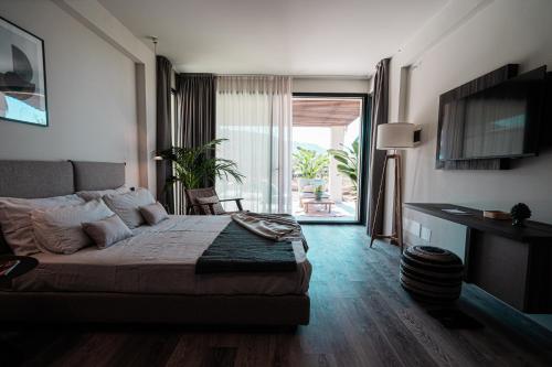 a bedroom with a bed and a sliding glass door at Insulae Resort in Cefalù