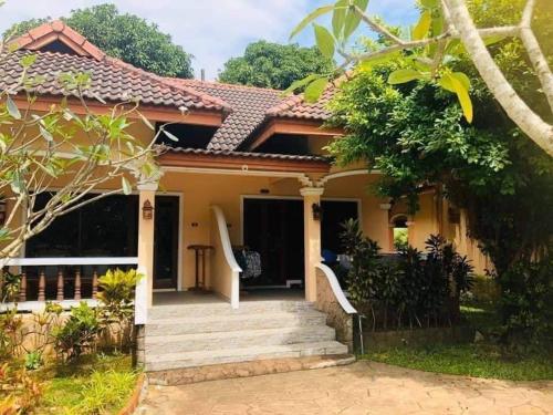 a house with a staircase leading to the front of it at Happy Lagoon Bungalow in Khao Lak