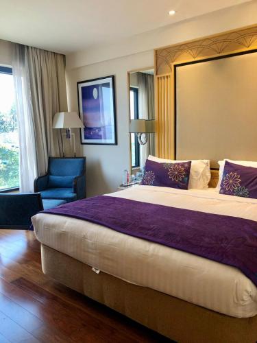 a hotel room with a large bed and a blue chair at Hotel Marine Plaza in Mumbai