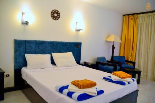 1 dormitorio con 1 cama grande y toallas. en El Khan Sharm Hotel en Sharm El Sheikh