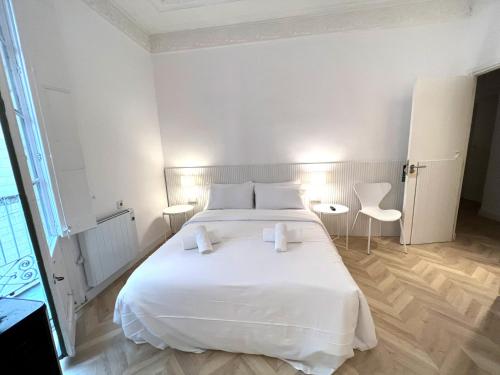 a bedroom with a white bed and two white chairs at The MO GOTIC in Barcelona