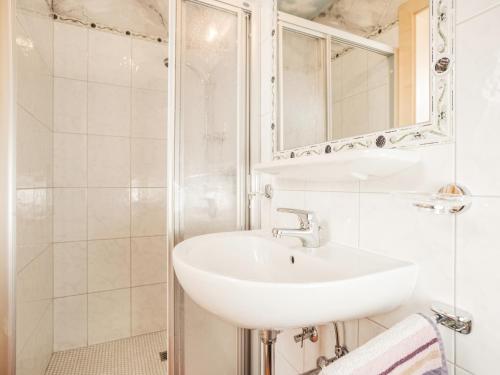 a white bathroom with a sink and a shower at Deluxe Apartment Sonnseite in Aschau