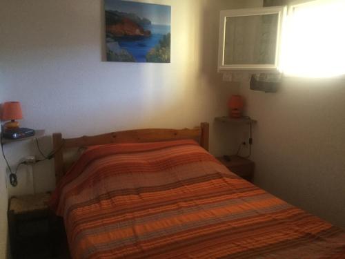 ein Schlafzimmer mit einem Bett mit einer Decke darauf in der Unterkunft Les Naïades in Balaruc-les-Bains