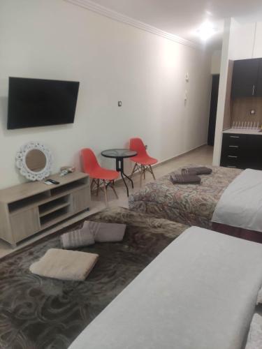 a hotel room with a bed and a table and chairs at G M 3 ROOMS KENTPO in the heart of the city in Larisa