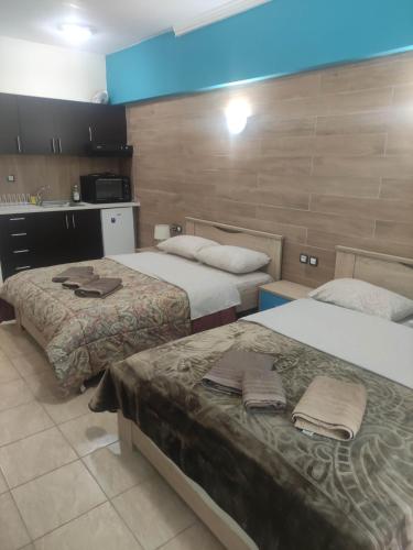 a hotel room with two beds and a kitchen at G M 3 ROOMS KENTPO in the heart of the city in Larisa