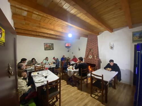 a group of people sitting at tables in a restaurant at Guesthouse Freskia in Theth
