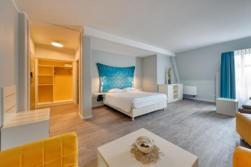 a bedroom with a bed and a living room at Ibis Styles Regensburg in Regensburg