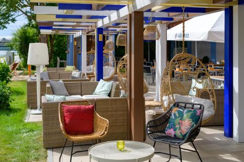 a patio with wicker chairs and tables at Ibis Styles Regensburg in Regensburg