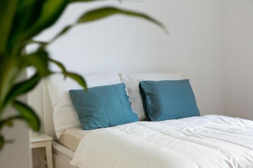 uma cama branca com duas almofadas azuis em Charming City Apartment em Graz