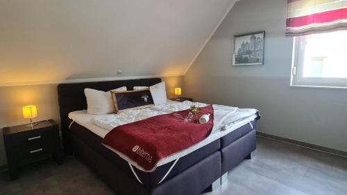 1 dormitorio con 1 cama con manta roja en Luxusferienhaus Seevilla Monaco am Fleesensee, en Göhren-Lebbin