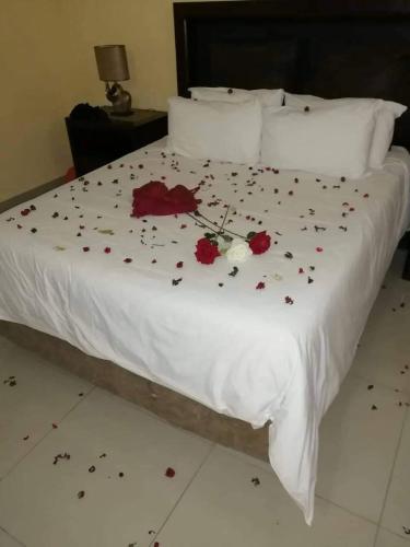 a white bed with flowers on it at Phokela Guest House in Mokopane