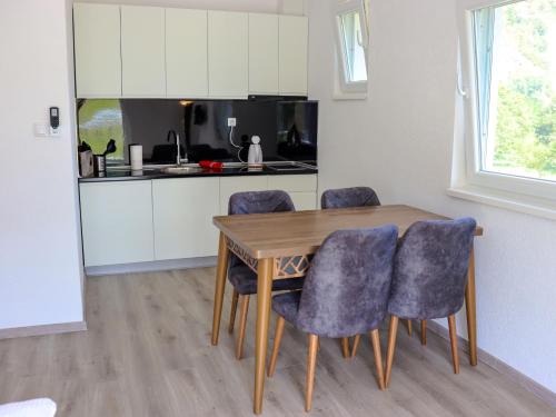 een keuken met een houten tafel en stoelen bij River Drina Apartments & Wellness in Bratunac