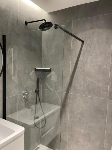 a shower with a glass door in a bathroom at Ladi Rooms in Tirana