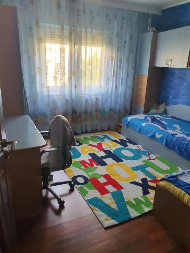 um quarto com uma secretária, uma cadeira e um tapete em Apartament Remali em Oradea