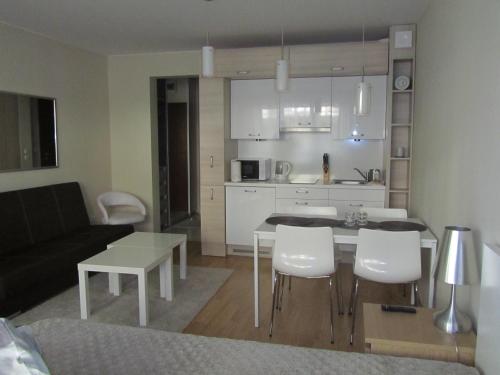 Il comprend une cuisine et un salon avec une table et des chaises. dans l'établissement Apartament 22 nad morzem, à Świnoujście