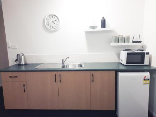 a kitchen with a sink and a microwave at The Coastal Nest in Sussex Inlet