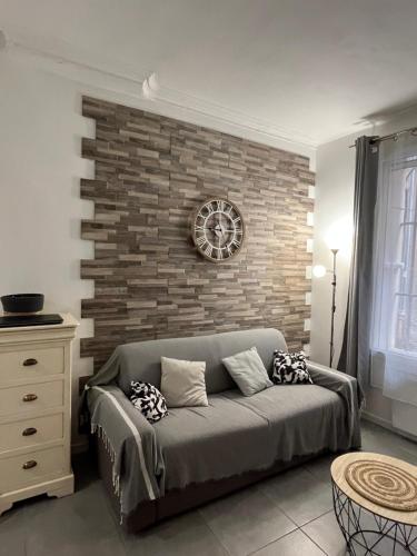un salon avec un canapé et un mur de briques dans l'établissement perle rare à la ciotat, à La Ciotat