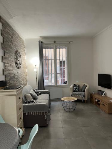 ein Wohnzimmer mit einem Sofa und einem TV in der Unterkunft perle rare à la ciotat in La Ciotat