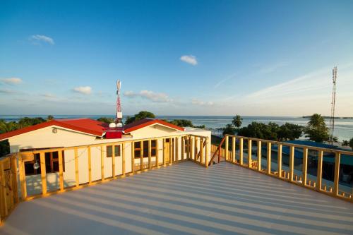 a boardwalk leading to a building with a view of the ocean at Tropic Tree Maldives in Gulhi