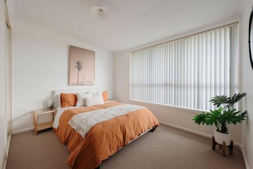 a bedroom with a bed and a large window at House on Hampson in Penguin