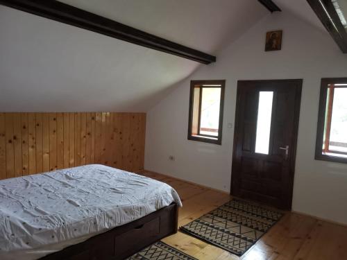um quarto com uma cama e uma porta de madeira em Pe-un Picior de Plai em Borca