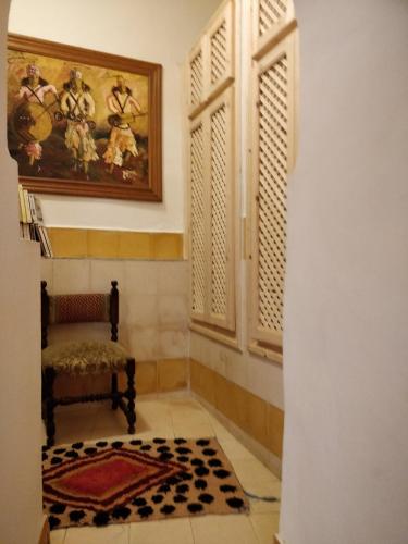 a room with a chair and a rug on the floor at Dar Nadia in El Jadida