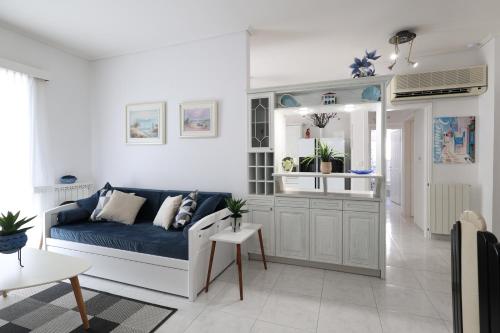 a living room with a blue couch in a room at Seaside Penthouse in Kalamata in Kalamata
