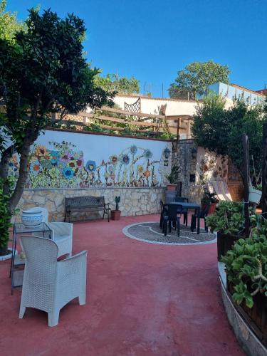 a patio with a table and chairs in front of a wall at Tabor 1 garden & parking in Naples