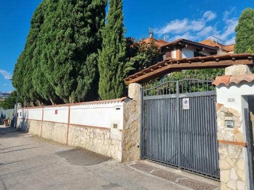 a gate in a stone wall with trees behind it at Tabor 1 garden & parking in Naples