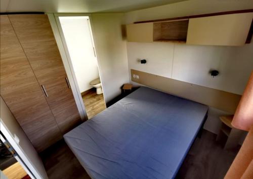 Habitación pequeña con cama y armario en Les papillons 441, en Litteau
