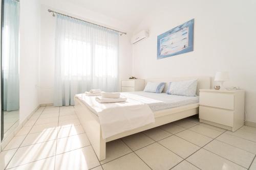 イラクリトサにあるVilla Dimitraの白いベッドルーム(ベッド1台、窓付)