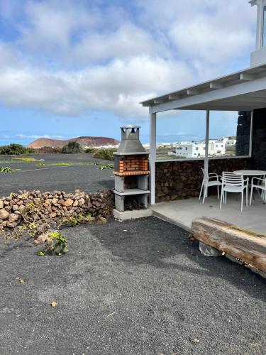 une terrasse avec une cuisinière, une table et des chaises dans l'établissement El Cercado, à Tinajo