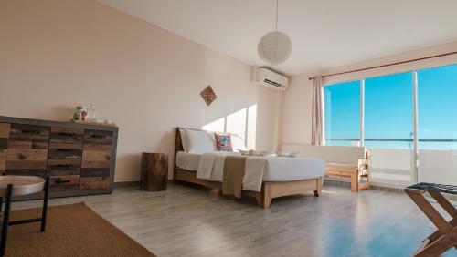 a bedroom with a bed and a large window at Lea Spa Hotel in Maafushi