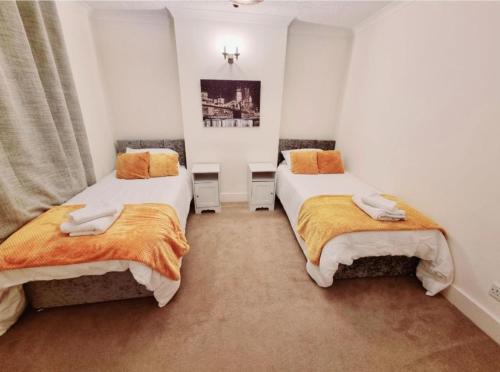 two beds in a room with white walls at Inviting 2-Bed Cottage in Windsor in Windsor
