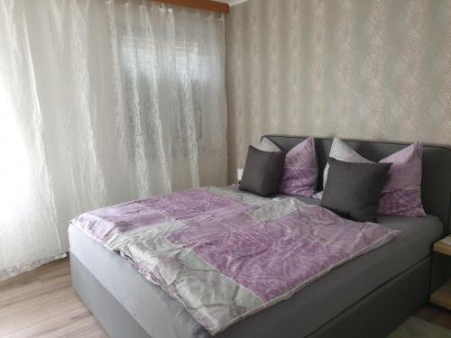 een bed met een paars dekbed en kussens bij Ferienwohnung Claudia in Salzburg