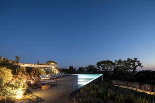 a villa with a swimming pool at night at Pa.te.os in Melides