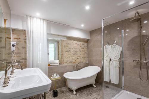 a bathroom with a tub and a sink and a shower at Castel de Très Girard - Teritoria in Morey-Saint-Denis