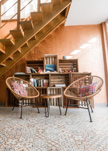 two chairs and a table in front of a book shelf at Lea Spa Hotel in Maafushi