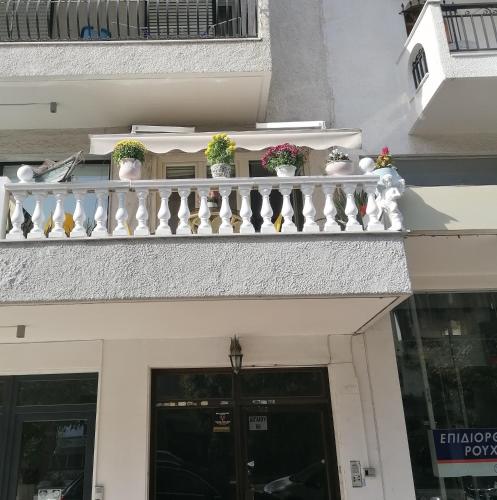 a balcony with potted plants on top of a building at STUDIO 66 στην kalamaria USEFUL in Thessaloniki