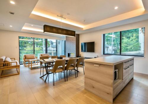 a kitchen and dining room with a table and chairs at Grand Phenix Hakuba in Hakuba