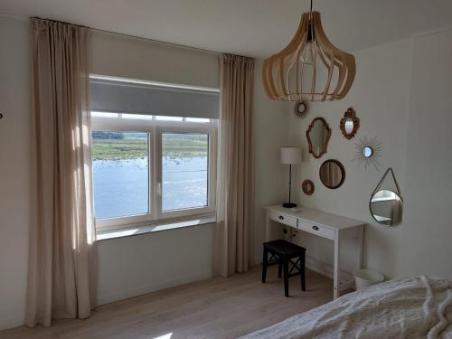 a bedroom with a bed and a window and a desk at Entre Deux Eaux in Lanaken