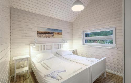 ein weißes Schlafzimmer mit einem Bett und einem Fenster in der Unterkunft Haus Otter in Göls