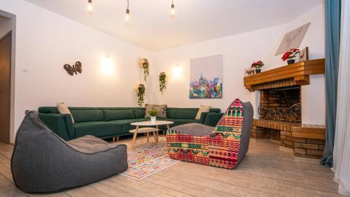 a living room with a green couch and a fireplace at Family TreeZ Premium Apartments in Poiana Brasov