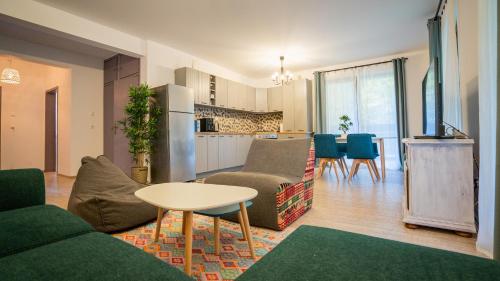 a living room with a couch and a table and a kitchen at Family TreeZ Premium Apartments in Poiana Brasov