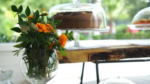 a vase with orange flowers sitting on a table at Parco d'Arte AltArt in Rende