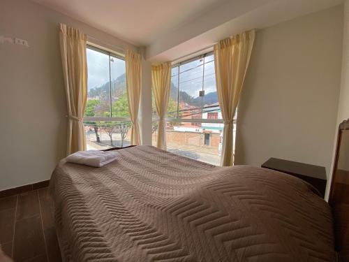 a bedroom with a large bed with a large window at Agradable departamento con estacionamiento gratis in Sucre