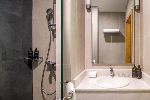 a bathroom with a sink and a shower at Adagio Doha in Doha