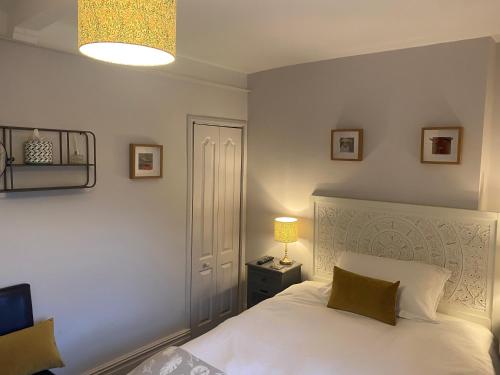 a bedroom with a white bed and a lamp at Talbot House Bed & Breakfast and Tearoom in Pateley Bridge
