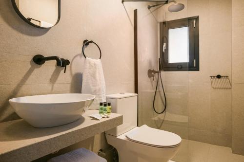 a bathroom with a sink and a toilet and a shower at Skala Hotel in Skala