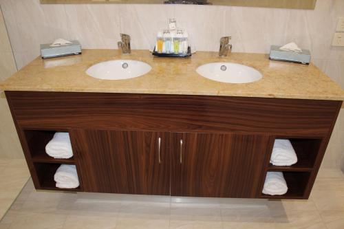 - Baño con 2 lavabos y encimera con toallas en Quality Hotel Regent Rockhampton en Rockhampton